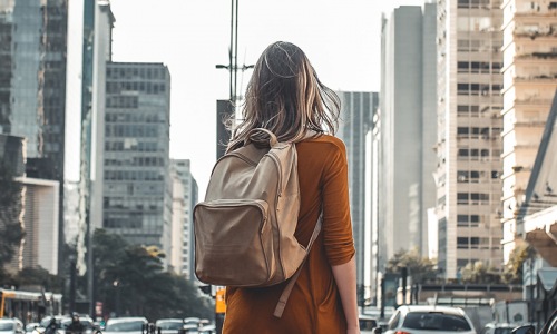 lifestyle image of a woman standing in the middle of a city